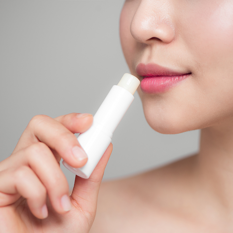 Woman-applying-lip-balm-moq-cosmetics-beauty-trading